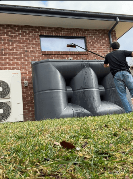Dion cleaning leather couches outside a Canberra home